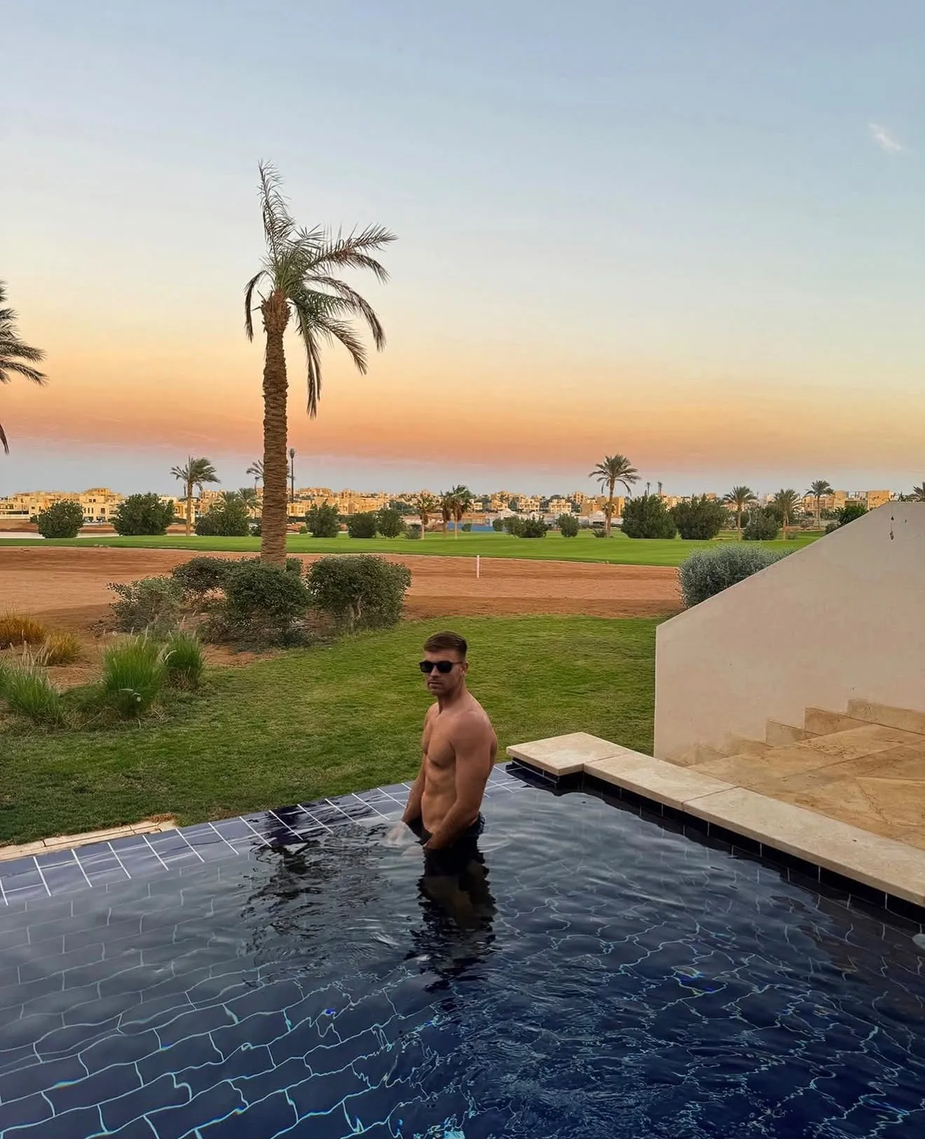 Eneko Andrés en una piscina al atardecer, en un resort de golf.